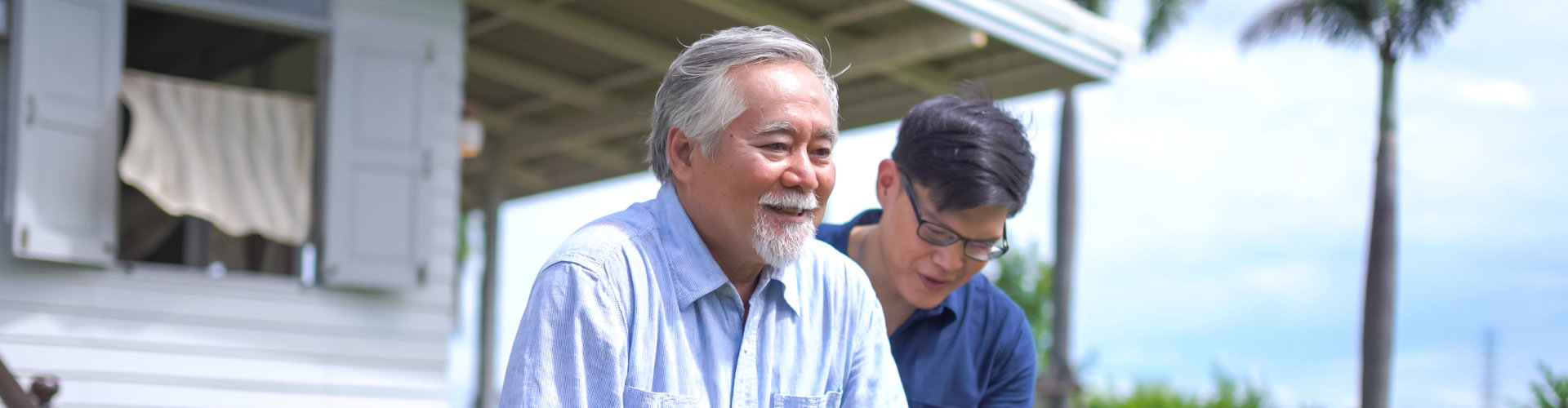 Male caregiver giving assistance to an elderly man in walking